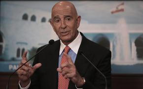 Tom Barrack in a red tie, blue dress shirt and black suit.