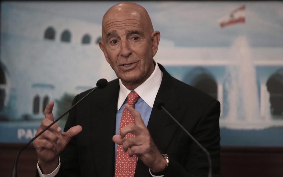 Tom Barrack in a red tie, blue dress shirt and black suit.