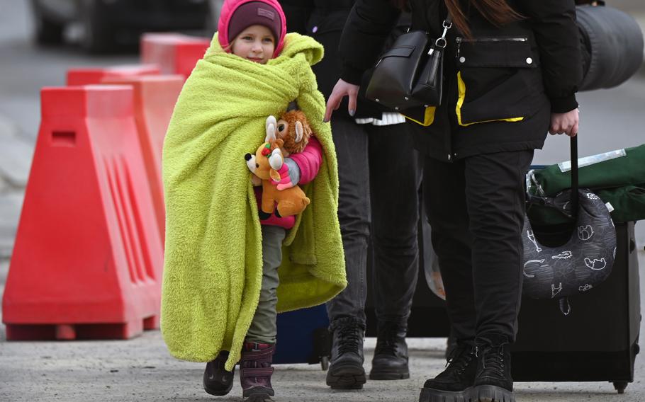 A girls hugs her stuffed animals as she crosses the border from Ukraine into Poland with her mother, March 2, 2022, at the Medyka crossing.