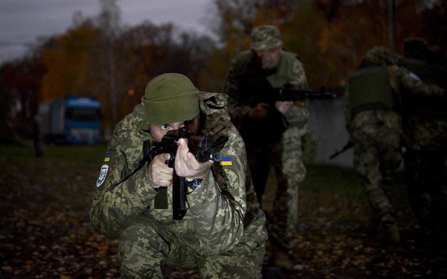 A Ukrainian soldier moves with his squad under simulated fire to retrieve a casualty during training at a site on the outskirts of Kyiv, on Oct. 27, 2022.