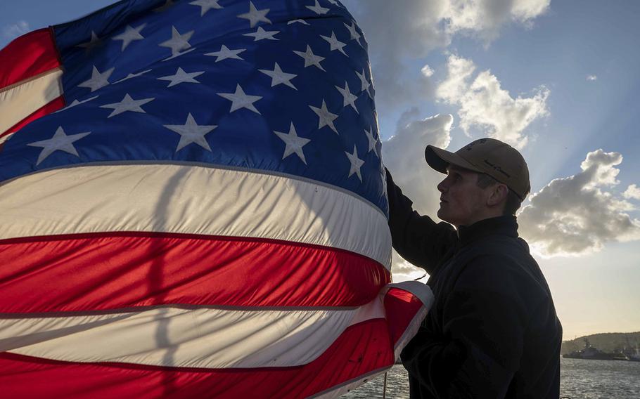 A U.S. sailor lowers the American flag aboard the Arleigh Burke-class guided-missile destroyer USS Roosevelt (DDG 80), June 12, 2021, near Gdynia, Poland.