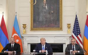 The leaders of Azerbaijan, the U.S. and Armenia seated at a long conference table, all with their arms folded before them.