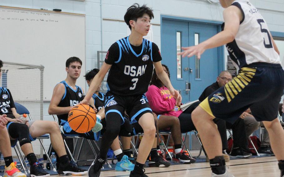 Osan‘s Jax Ibarra looks for room to dribble against Cheongna Dalton’s Seong Woo during Saturday’s Korea boys basketball game. The Cougars won 48-40.