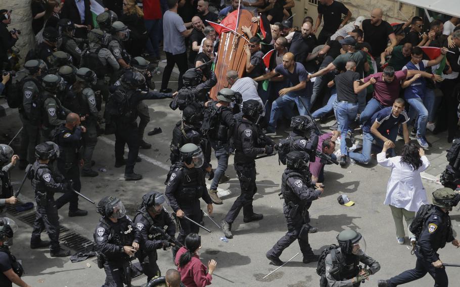 Israeli police clash with mourners as they carry the casket of slain Al Jazeera veteran journalist Shireen Abu Akleh during her funeral in east Jerusalem, Friday, May 13, 2022. 