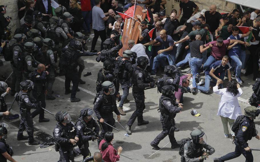 Israeli police clash with mourners as they carry the casket of slain Al Jazeera veteran journalist Shireen Abu Akleh during her funeral in east Jerusalem, Friday, May 13, 2022.