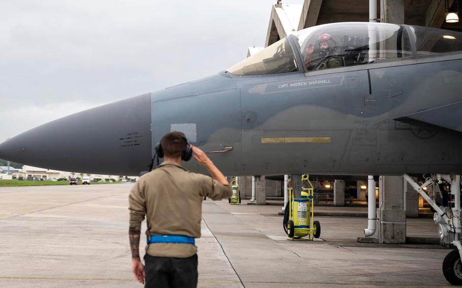A crew chief with the 44th Aircraft Maintenance Unit salutes an F-15 Eagle pilot taxiing for a final take-off from Kadena Air Base, Okinawa, Dec. 1, 2022.