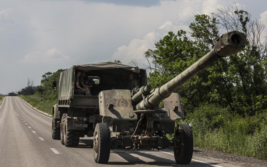 Ukrainian forces transport a 152 mm howitzer along a main road in the Donbas region of eastern Ukraine on June 12, 2022. 