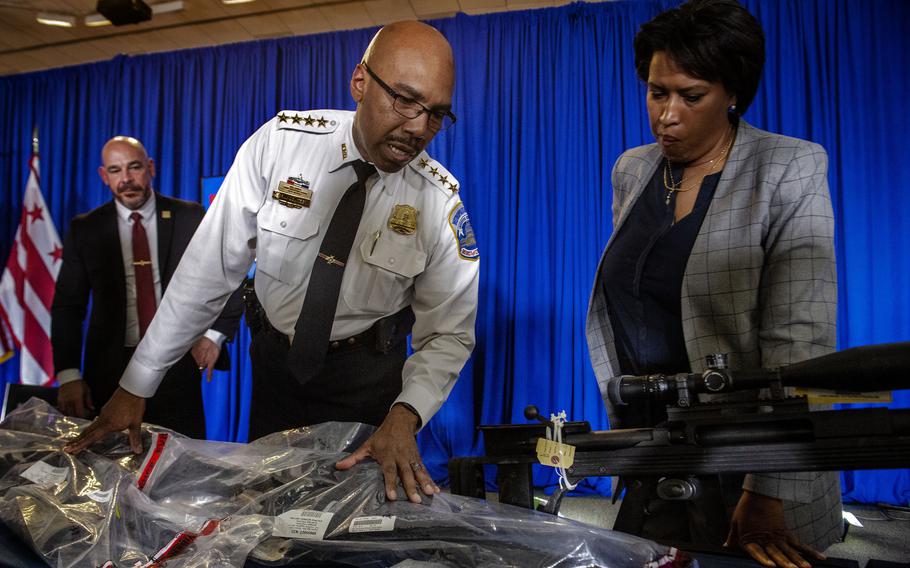 D.C. Police Chief Robert Contee, center, Mayor Muriel Bowser and Deputy Mayor for Public Safety Chris Geldart display guns seized by police at a news conference Monday.