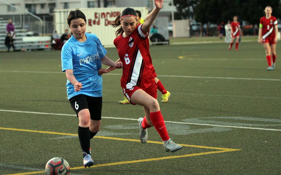 Seisen’s Lily Kawahata and Nile C. Kinnick’s Julia Angelinas chase the ball during Tuesday’s Kanto Plain soccer match. The Red Devils won 13-1.