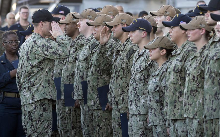 Capt. Joel Lang, commanding officer of amphibious assault carrier USS Tripoli, advances sailors during a frocking ceremony on the flight deck, June 29, 2022, in the East China Sea. Navy commanders recently were ordered to fix problems with paying sailors consistently, accurately and on time, the service announced July 14.