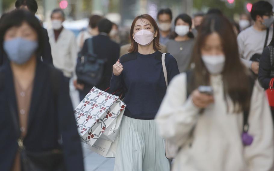 People wearing face masks to help curb the spread of the coronavirus walk at the Ginza shopping district on Tokyo Monday, Nov. 8, 2021.