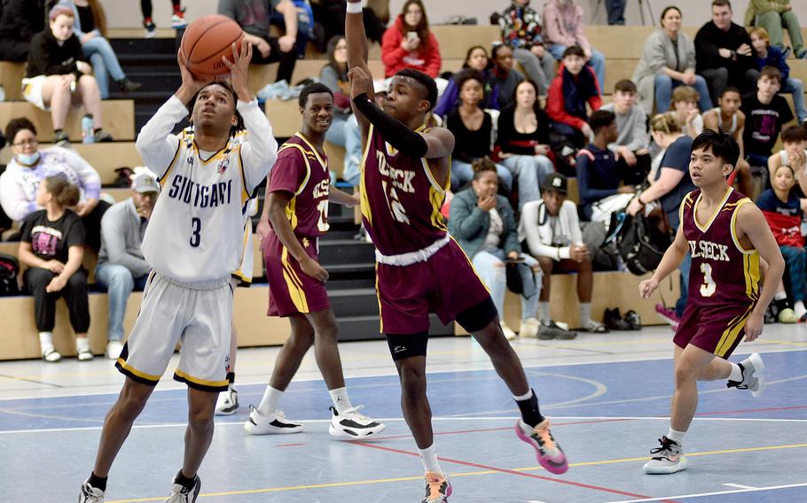 Stuttgart's Tyler Jackson, left, goes up for a shot during round-robin action of the Division I DODEA European Basketball Championships on Friday at Ramstein High School on Ramstein Air Base, Germany. Defending are Vilseck's Kendall Terrell, center, and Caleph Andrade, right.