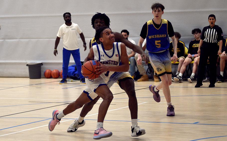 Ramstein junior Christian Roy drives in the lane against Wiesbaden forward Zion Thompson during pool-play action of the DODEA European basketball championships on Feb.14, 2024, at the Wiesbaden Sports and Fitness Center on Clay Kaserne in Wiesbaden, Germany.