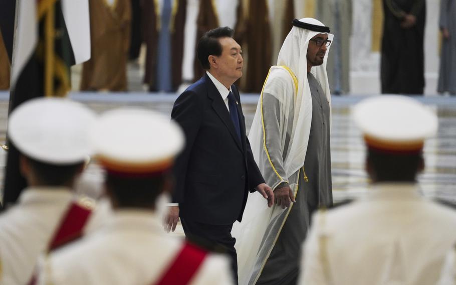 South Korea President Yoon Suk Yeol, center left, and Emirati leader Sheikh Mohammed bin Zayed Al Nahyan walk past an honor guard at Qasar Al Watan in Abu Dhabi, United Arab Emirates, Sunday, Jan. 15, 2023. 