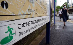 A sign points the way to an evacuation area in Tokyo's Minato ward, Friday, May 27, 2022. 