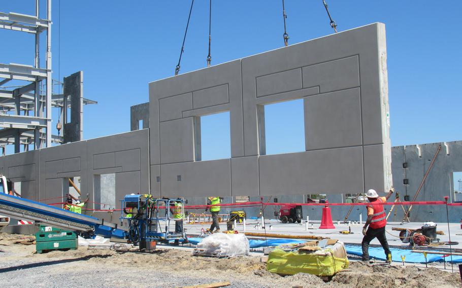 Pre-formed concrete panels are lowered into place while constructing a dormitory at Tyndall Air Force Base. 