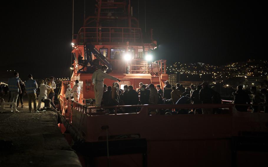 Migrants arrive aboard a Spanish coast guard rescue ship at Arguineguin port, in Gran Canaria island, Spain, late Nov. 21, 2021. Spanish rescuers have saved and disembarked more than 400 migrants and asylum seekers to the Canary Islands in the past two days as they attempted to reach the Atlantic Ocean archipelago from West Africa on overcrowded and often unsafe boats.