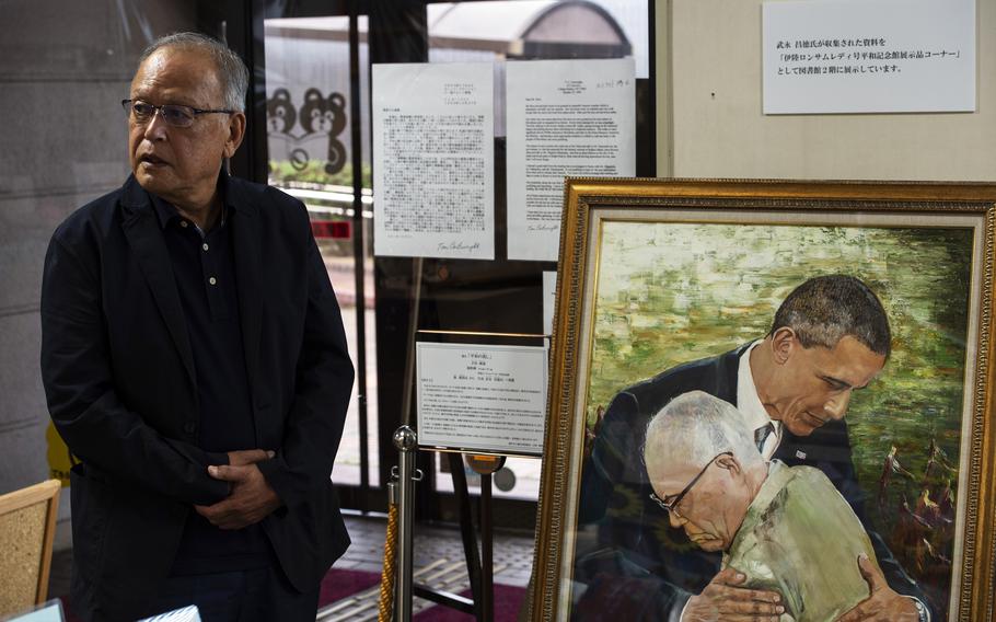 Masanori Takenaga, owner of the Ikachi Lonesome Lady Peace Memorial Museum, stands next to "A Hopeful Sign" at the public library in Yanai city, Japan, July 27, 2022. 