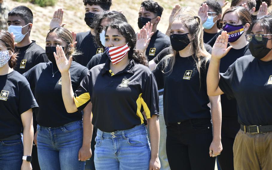 Recruits recite the oath of enlistment at Fort Hunter Liggett, Calif., on May 15, 2021. The Army is now offering up to $50,000 and guaranteed first assignment selection to qualifying recruits.