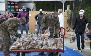 North Carolina Army National Guard Soldiers assigned to 5th Battalion, 113th Field Artillery Regiment, and other volunteers stack bags of potatoes that are being distributed to veterans and military families in Hillsborough, North Carolina on May 13, 2020. The military-themed food distribution was coordinated by Orange County Social Services. More than 900 NCNG Soldiers and Airmen have been activated in response to COVID-19 relief efforts to help support NC Emergency Management, N.C. Department of Health and Human Services, and their local communities. (U.S. Army photo by Staff Sgt. Mary Junell)