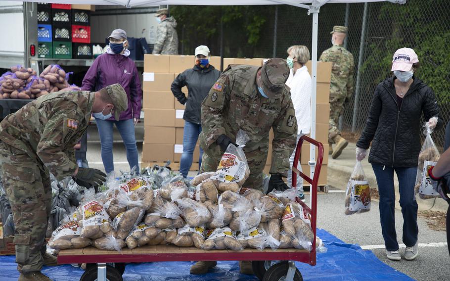 North Carolina Army National Guard soldiers and other volunteers stack bags of potatoes that were being distributed to veterans and military families in Hillsborough in May 2020. 