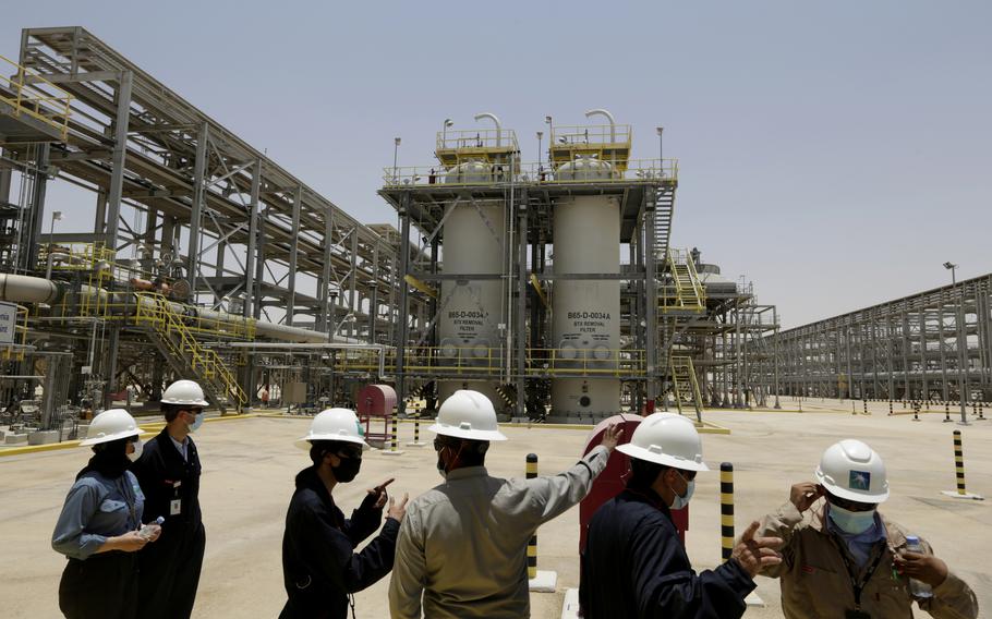 Saudi Aramco engineers and journalists look at the Hawiyah Natural Gas Liquids Recovery Plant in Hawiyah, in the Eastern Province of Saudi Arabia, on June 28, 2021. One of the world's largest oil producers, Saudi Arabia, announced on Saturday, Oct. 23, 2021, it aims to reach “net zero” greenhouse gas emissions by 2060.