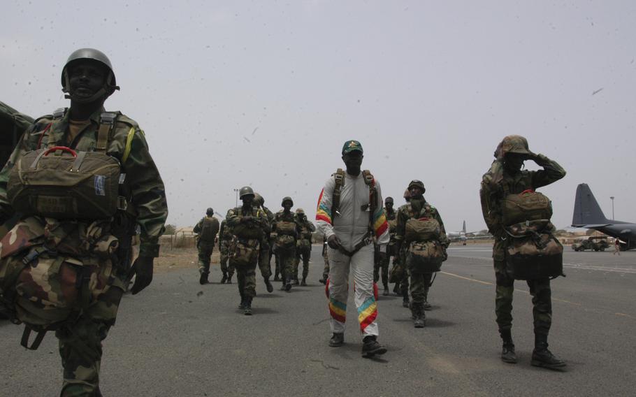 Senegalese paratroops and commandos march toward a U.S. Air Force C-130 Talon. The elite troops joined U.S. Army Special Forces in a combined skydive exercise. 