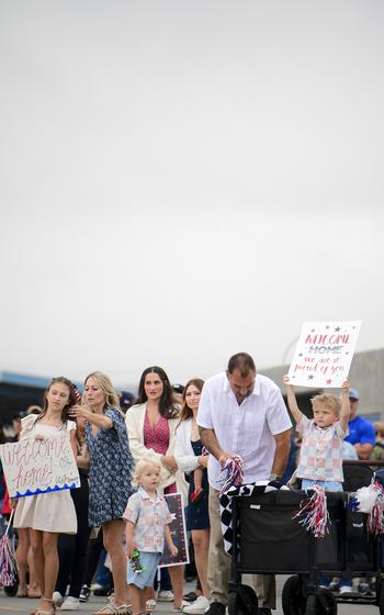 A family poses for a photo while holding signs
