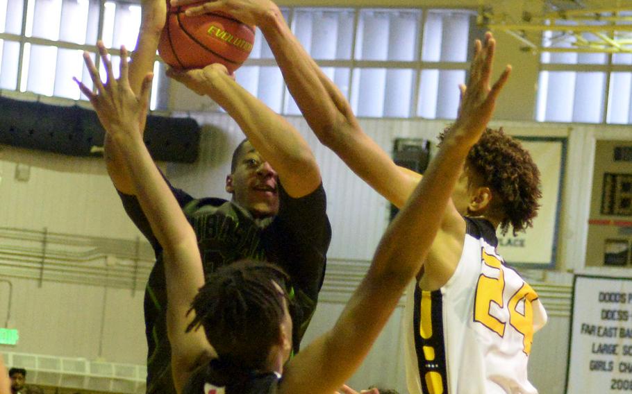 Kubasaki's Terrence Reece has his shot blocked by Kadena's Jeremiah Lewis during Thursday's Okinawa basketball game. The Panthers rallied from an 11-point deficit to win 39-34.