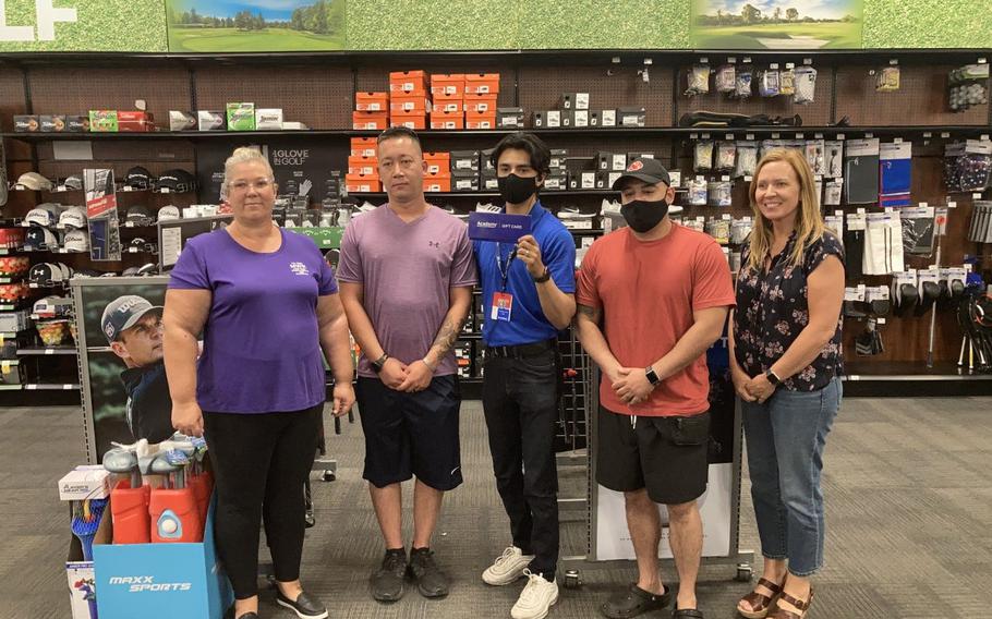 Marlo Brestar, left, and Michele Wiernicki, far right, both from the Fort Bliss Morale, Welfare and Recreation Division, and Academy Sports + Outdoor store employee Jacob Arellano rewarded the two winning military dads, Sgt. 1st Class Kyle Tranchitello and Staff Sgt. Eddie Hernandez, with $1,000 gift cards.