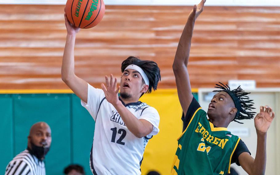 Zama’s Joben Silang drives to the basket against Robert D. Edgren’s Messai Cain during Saturday’s DODEA-Japan boys basketball game. The Trojans won 64-61.