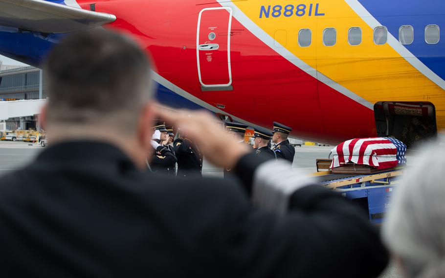 A casket being escorted onto a plane