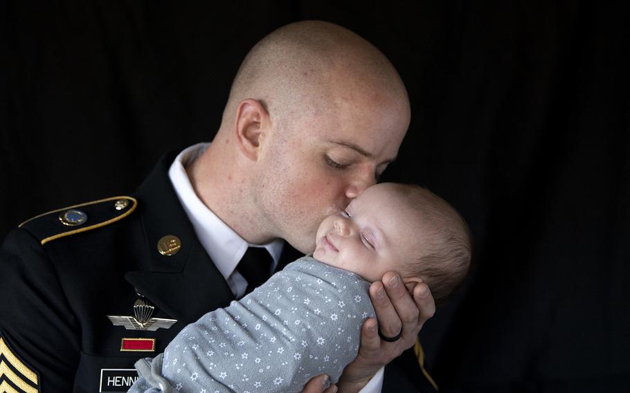 Army Staff Sgt. Alex Henninger kisses his newborn son, Hugo.