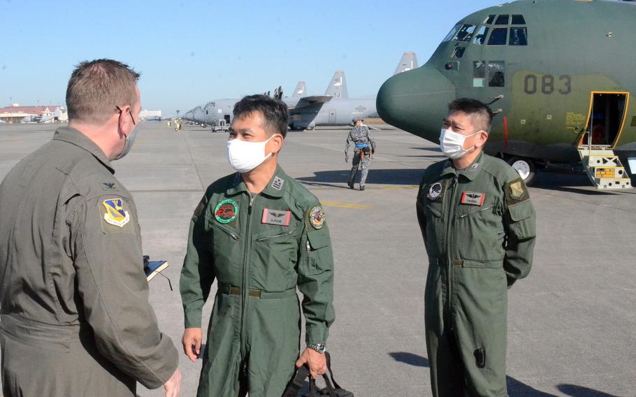 Col. Kevin Martin, commander of the 374th Operations Group, welcomes Col. Hiroshi Fuji, center, commander of the Japan Air Self-Defense Force's 1st Tactical Aircraft Flight Group, to Yokota Air Base in western Tokyo, Thursday, Nov. 4, 2021.