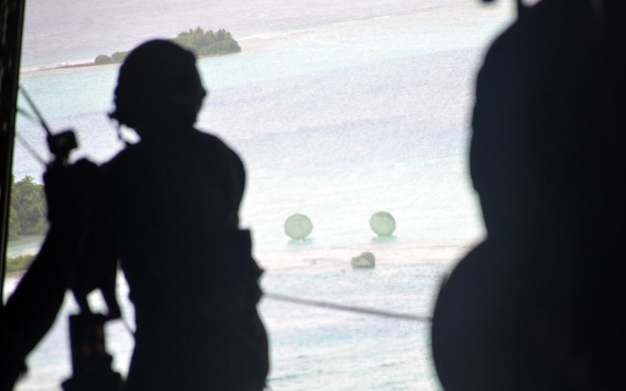 Crates filled with Operation Christmas Drop donations are parachuted from an Air Force C-130J Super Hercules toward the Eauripik islands in the Federated States of Micronesia, Wednesday, Dec. 7, 2022. 