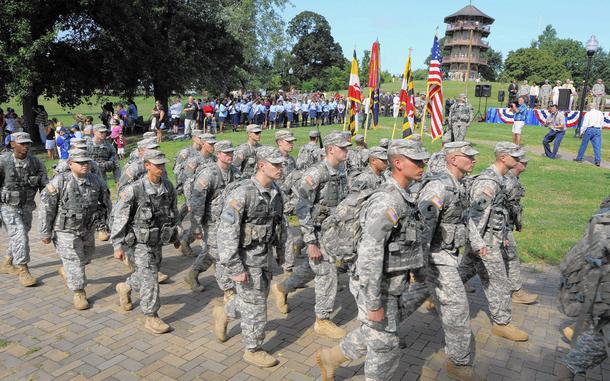 Streamers are displayed atop a flag as soldiers of the Maryland Army National Guard's 175th Infantry Regiment march.