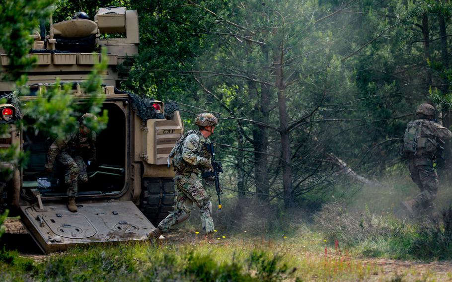 Soldiers dismount an M2 Bradley Fighting Vehicle during training at Drawsko Pomorskie, Poland, June 16, 2022. President Joe Biden is expected to announce a U.S. troop increase in Poland and the extension of some of the deployments to Poland and the Baltic states that came in the days ahead of Russia’s February invasion of Ukraine.