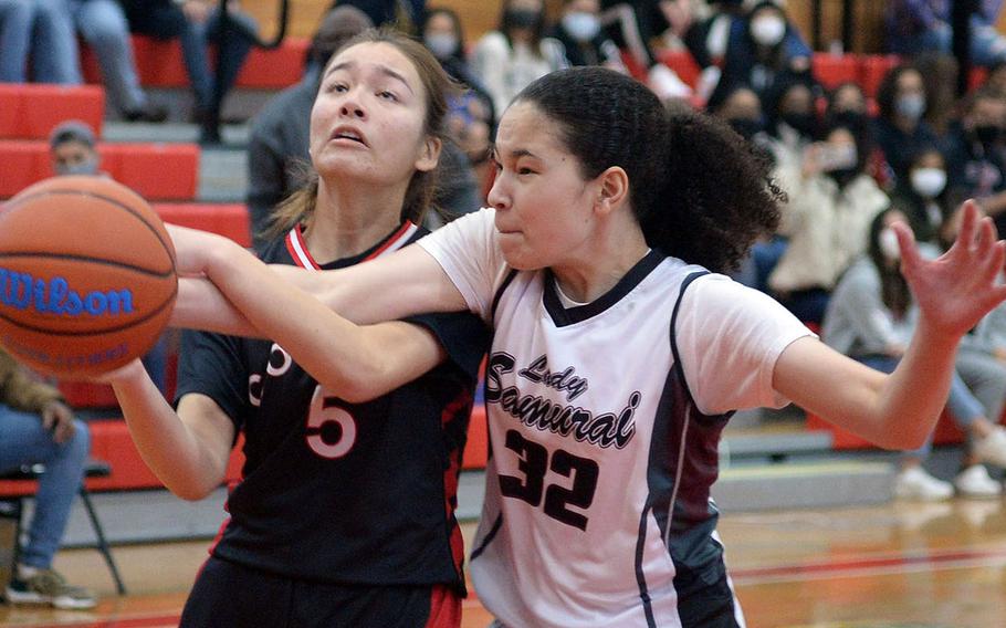 E.J. King's Aileen FitzGerald tries to shoot against Matthew C. Perry's Nyla Matos during Saturday's DODEA-Japan basketball game. The Cobras won 56-9.