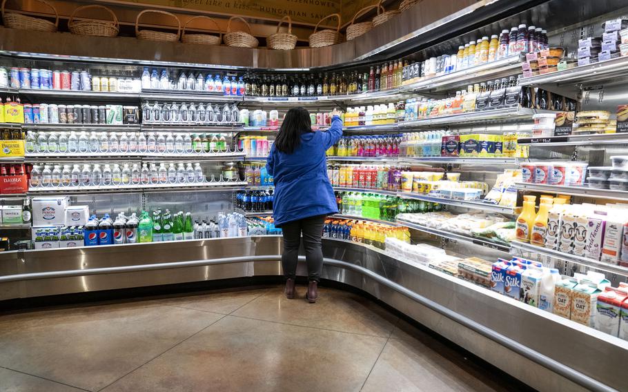 A woman picks up dinner at a grocery store in Glen Cove, N.Y.