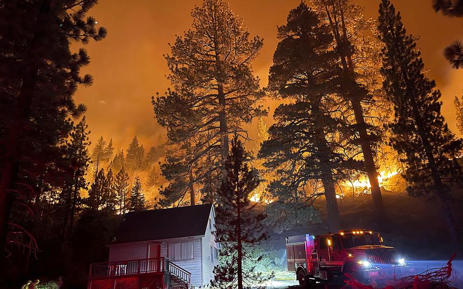 Firefighters protect a home from the Caldor Fire off of S. Upper Truckee Road  in the Christmas Valley area of the Tahoe Basin, Monday evening, Aug. 30, 2021, near South Lake Tahoe, Calif. 