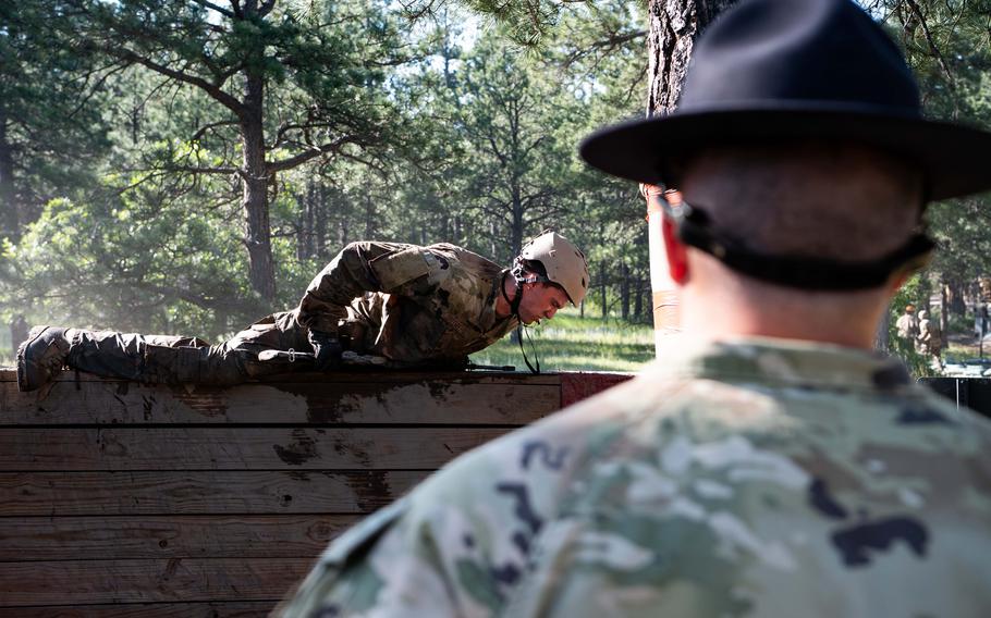 A cadet climbs over a wall
