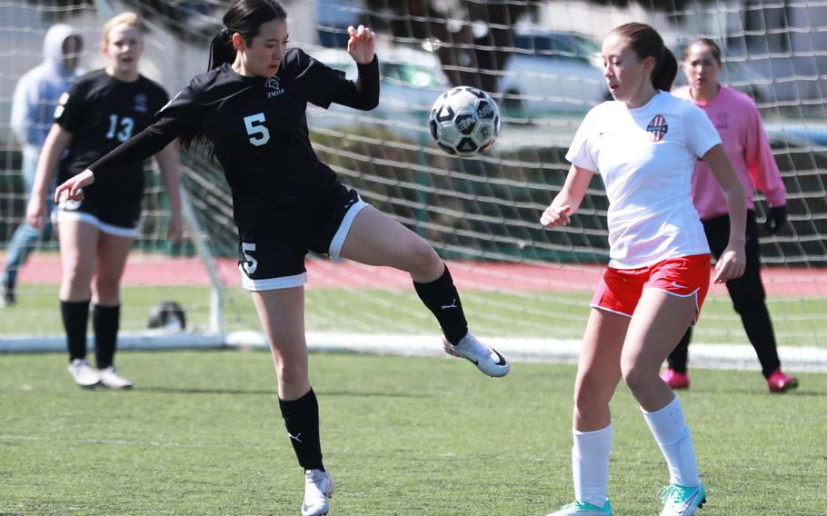 Zama’s Sara Zambrano tries to steady the ball against Nile C. Kinnick’s Victoria Justice during Saturday’s DODEA-Japan girls soccer match. The Red Devils won 6-0.