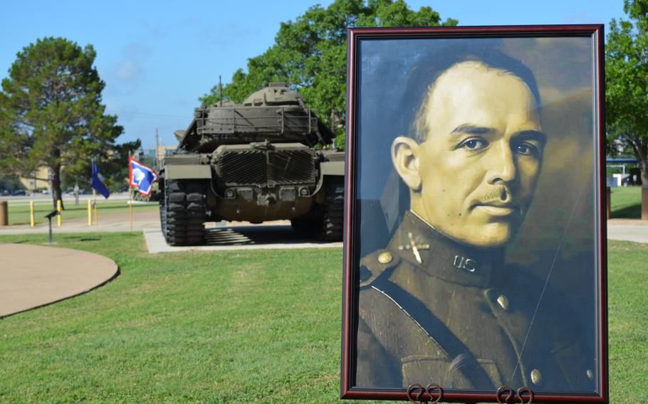 A portrait of Col. Robert B. Hood displayed on a lawn in front of the back of a tank.