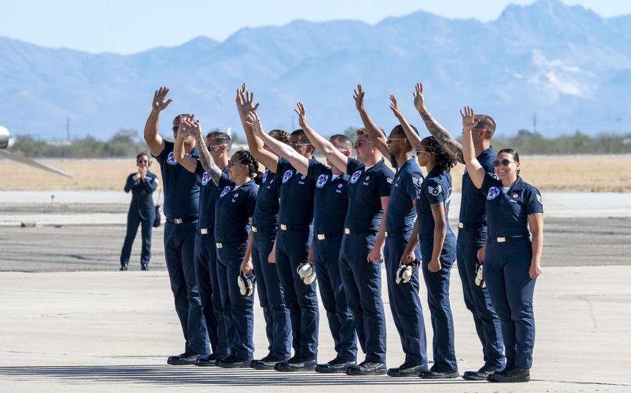 A group of people wave to the sky