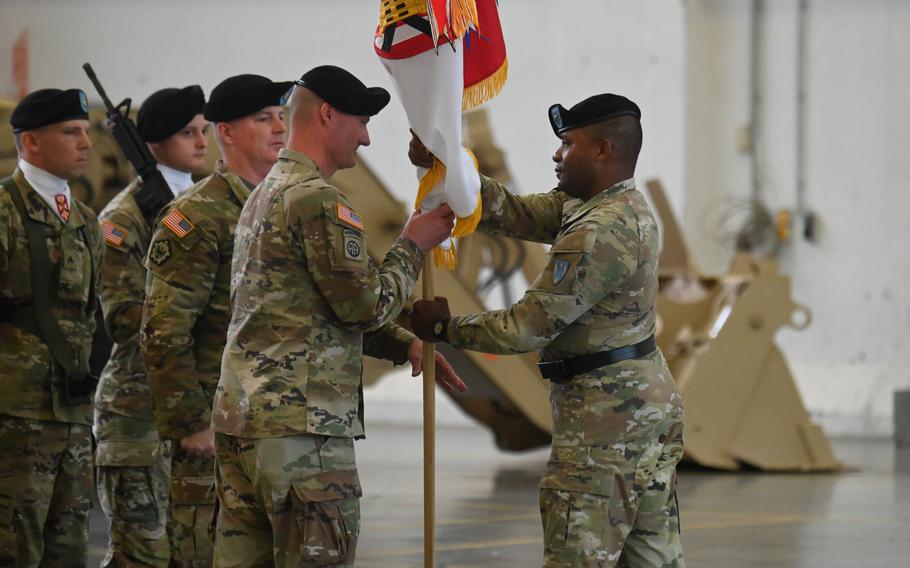 Army Col. Kyle Moulton takes the brigade colors from Brig. Gen. Ronald Ragin, head of the 21st Theater Sustainment Command, during the 7th Engineering Brigade’s reactivation ceremony July 27, 2023, at Katterbach Kaserne in Ansbach, Germany.