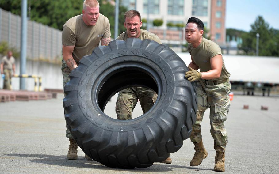 From left, Tech. Sgt. Matthew Waldeck, Senior Airman Jake Stallone and Staff. Sgt. Joseph Park, from Incirlik Air Base, Turkey’s 728th Air Mobility Squadron, flip a tire during the endurance event at the Port Dawg Rodeo at Ramstein Air Base, Germany, July 6, 2022.