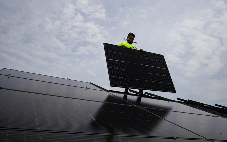 Nicholas Hartnett, owner of Pure Power Solar, installs a solar array on the roof of a home in Frankfort, Ky., July 17, 2023. 