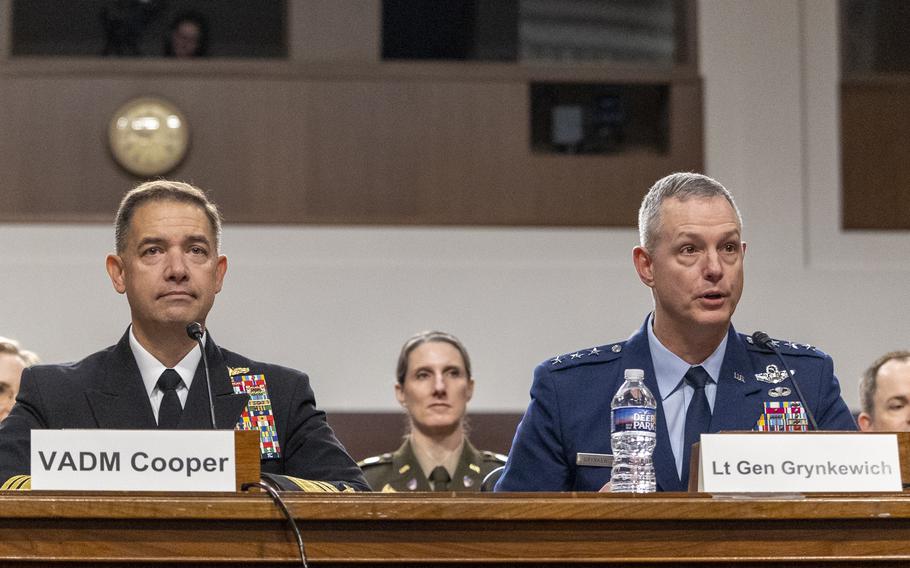 Charles Cooper and Alexus Grynkewich in uniform sitting at a table.