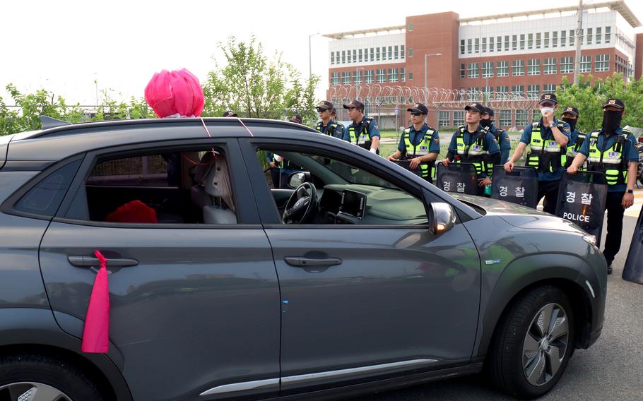 A vehicle driven by a protester who opposes the U.S. military presence in South Korea is blocked by police in front of Camp Humphreys, South Korea, Thursday, July 27, 2023.