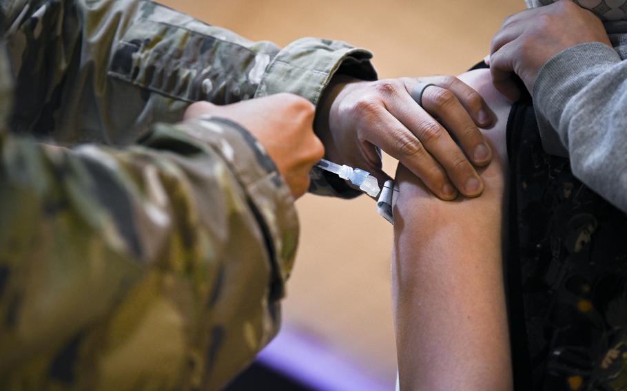 U.S. Air Force Capt. Angel Colon administers the Pfizer-BioNTech vaccine to a high school student at Royal Air Force Lakenheath, England, on June 4, 2021. 